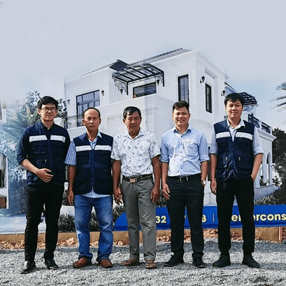 Nhóm khách hàng và kỹ sư đứng trước backdrop mô hình nhà ở