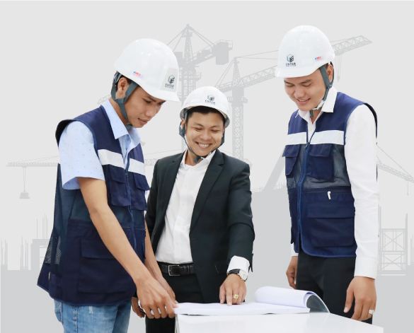 Ba kỹ sư cùng xem bản vẽ kỹ thuật trên bàn làm việc